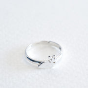 Sterling Silver Adjustable size ring with small bunny sits on a grey background